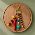 Ariel La Boutique bohemian beaded keychain with a red horn, turquoise heart, pearls, and crystals on a gold clasp.