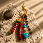 Ariel La Boutique bohemian beaded keychain with a red horn charm, turquoise heart, pearls, and crystals on a stone.