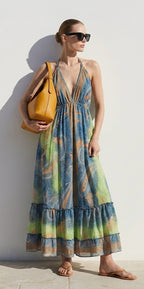Ariel La Boutique bohemian maxi dress with paisley print, halter neck, and tiered skirt, worn with a mustard leather bag.