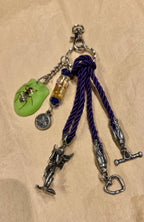 Ariel La Boutique whimsical keychain with a lime-green beetle resin charm, fairy pendant, and purple twisted cord.