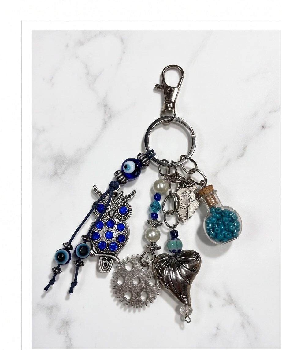 Ariel La Boutique owl and heart charm keychain with blue crystals, evil eye beads, and a miniature glass bead bottle.