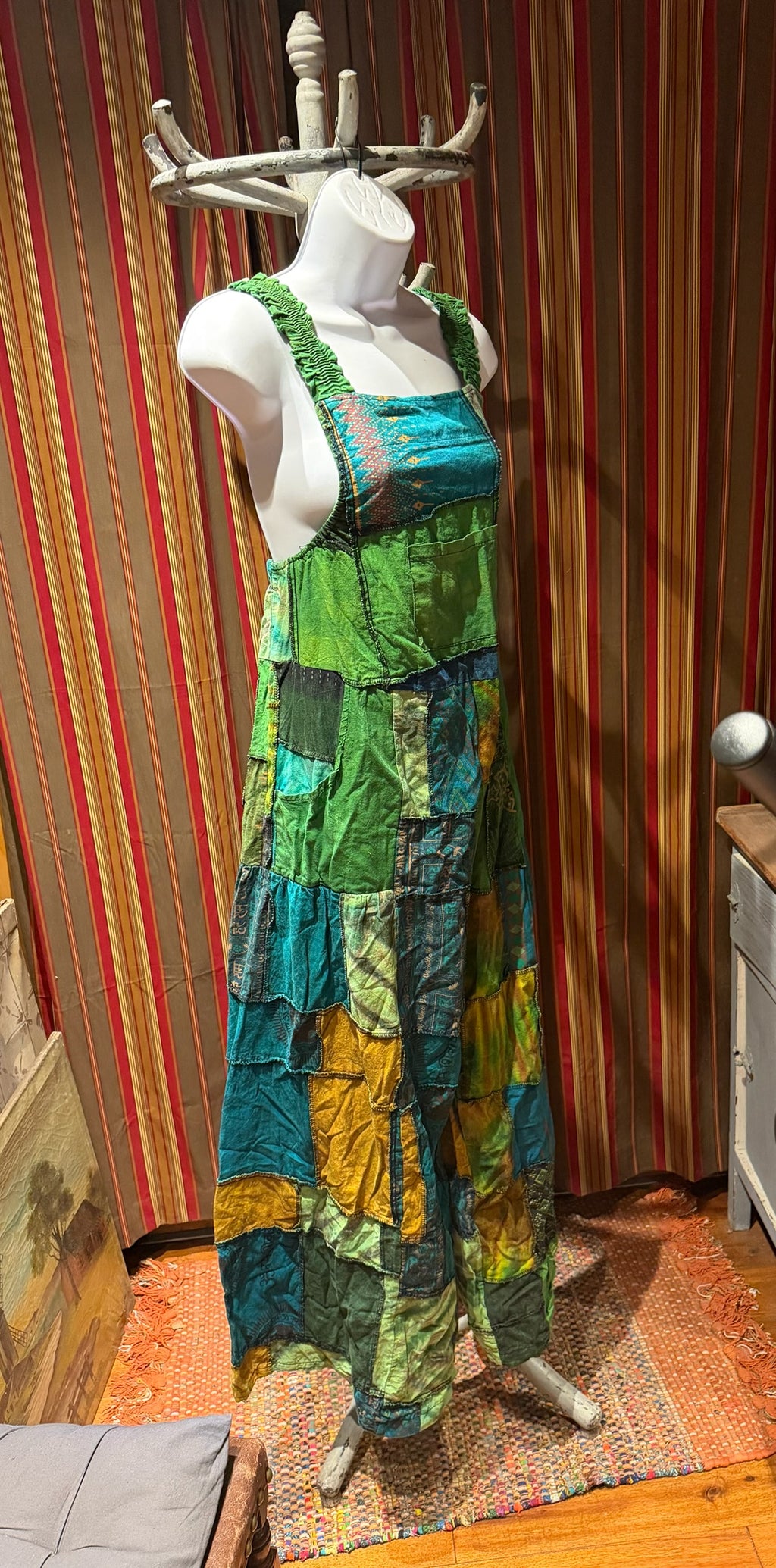 Ariel La Boutique bohemian patchwork overall dress in green, teal, and mustard cotton with shirred shoulder straps.