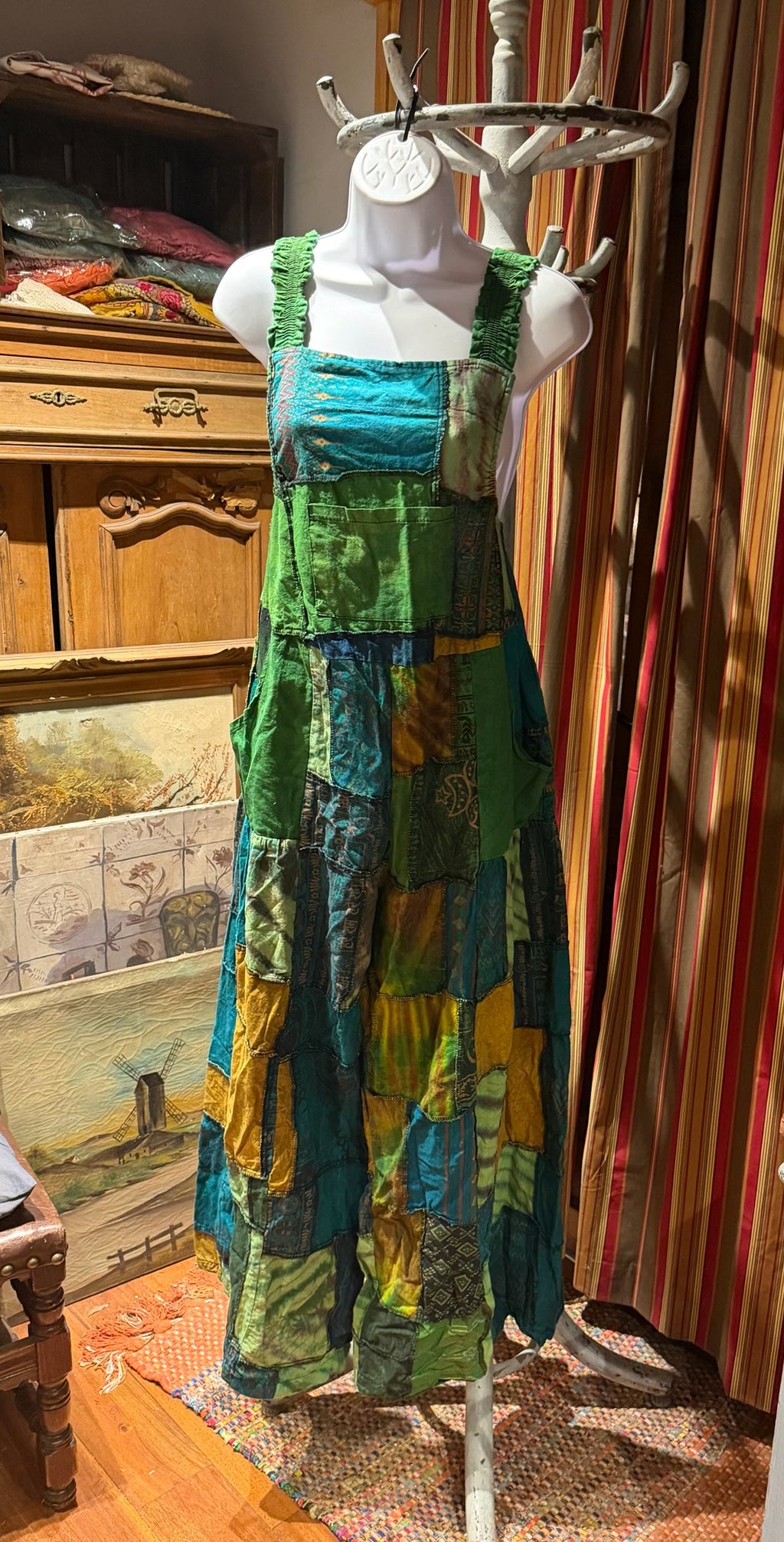 Ariel La Boutique bohemian patchwork overall dress in green, teal, and mustard cotton with wide shirred straps.