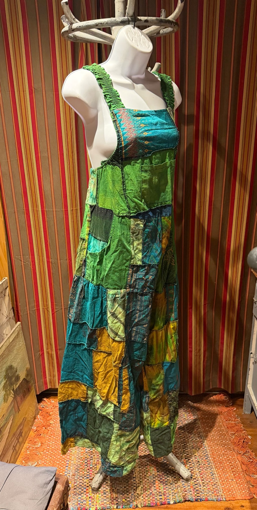 Ariel La Boutique bohemian patchwork overall dress in green, teal, and mustard cotton with shirred shoulder straps.