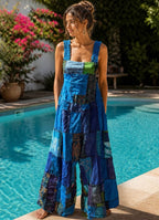 Ariel La Boutique patchwork wide leg sleeveless jumpsuit in blue and green tones worn by a woman by a pool.