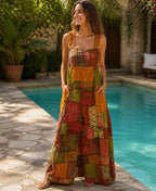 Ariel La Boutique bohemian patchwork wide-leg jumpsuit in earthy tones with ruffled straps worn by a smiling woman.