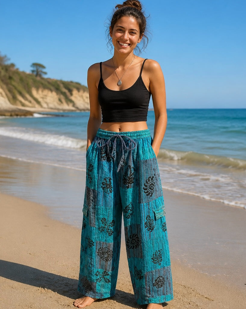 Ariel La Boutique teal and blue patchwork wide-leg lounge pants with black floral prints and side cargo pockets.