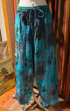 Ariel La Boutique teal and blue patchwork wide-leg lounge pants with black floral block-print and drawstring waist.