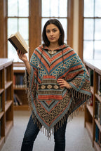 Ariel La Boutique unisex hooded poncho featuring a vibrant Southwestern geometric pattern, kangaroo pocket, and fringe.